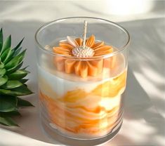 an orange and yellow candle sitting next to a pineapple