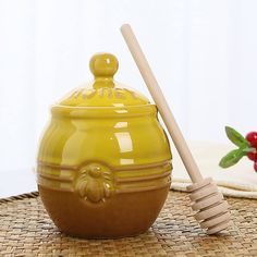 a yellow ceramic jar with a wooden stick in it