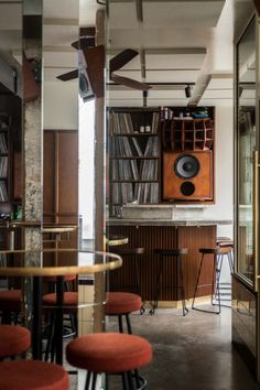 a room filled with lots of furniture and bookshelves in front of a bar