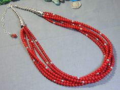 Item Details Newly handcrafted with quality gemstones & Navajo silver. Photos are part of the description details. Listing is for Necklace only. Coin and background decor not included. Marked "925" Genuine red bamboo Coral. 5 strands of 4mm size beads. Necklace is adjustable from 24" to 29". I can add more chain if more length is needed. Navajo handmade seamed bench beads and stamped Bench beads; 8mm, 7mm, 6mm and 5mm size. Sun stamped End Caps/Cones. Sterling silver hook clasp. Weighs 86 grams. Thank you for stopping by 😊❗ Red Southwestern Style Jewelry Gift, Southwestern Style Red Jewelry For Gifts, Southwestern Style Red Jewelry For Gift, Southwestern Red Gemstone Jewelry, Red Sterling Silver Jewelry For Festivals, Southwestern Style Red Gemstone Jewelry, Red Spiritual Jewelry With Gemstone Beads, Handmade Southwestern Red Jewelry, Southwestern Style Silver Beads Jewelry For Gifts