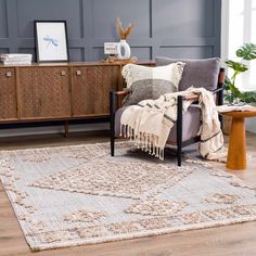 a living room with a rug, chair and sideboard on the floor in front of it