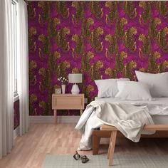 a bedroom with pink and gold wallpaper, white bedding and wooden flooring