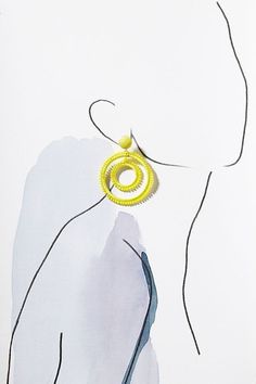 a drawing of a woman's profile with yellow earrings