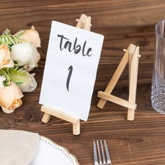 a table number sign sitting on top of a wooden table