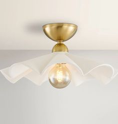 a light that is on top of a white ceiling fixture with a glass bulb in the middle