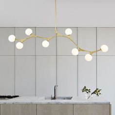 a modern kitchen with marble counter tops and gold fixtures