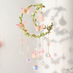 a dream catcher with flowers and crystals hanging from it's side on a wall