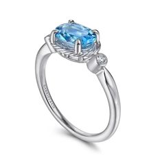 Enhance any outfit with a mesmerizing blue hue with this December birthstone ring from the Hampton collection. The east-west set oval cut swiss blue topaz stone, surrounded by twisted gold, adds a striking pop of color. Flanking the stone are bezel set round diamonds totaling 0.02cts, creating a beautifully balanced and elegant design. Ring takes 2-3 weeks for Gabriel to create and will ship immediately after completion. Rush delivery available depending on style and upon request. Available in 1 Gabriel Jewelry, Diamond Three Stone Ring, December Birthstone Ring, Classic Wedding Band, Jewelry Appraisal, Three Stone Ring, Blue Topaz Stone, Swiss Blue Topaz, Topaz Stone