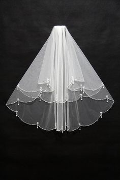 the veil is white and has beaded trim