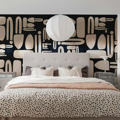 a bedroom with black and white wallpaper has a large bed in front of it