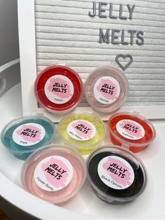 jelly melts are arranged in small containers on a white surface with a sign that says jelly melts