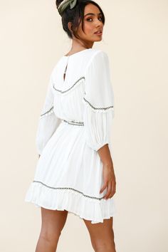 White tunic style dress  Partially lined  Three-quarter sleeves  Removable waist tie  Pom-pom trim detail  Non stretchy   Breeze through your day in our boho-chic Marionette dress. It's super versatile and we are loving the pom-pom trim detail. Perfect for lunch dates with your girls paired with ankle boots and a felt hat or dress it up with tan mules and some gold hoops for a chic look we are loving. Flowy Dresses With 3/4 Sleeves For Vacation, Bohemian Dresses With 3/4 Sleeves For Vacation, Bohemian 3/4 Sleeve Dresses For Vacation, Bohemian 3/4 Sleeve Vacation Dresses, Bohemian Half Sleeve Dresses For Vacation, Beach Boho Dress With 3/4 Sleeves, Spring Bohemian Mini Dress With 3/4 Sleeves, Summer Boho Dress With 3/4 Sleeves For Beach, Summer Boho Beach Dress With 3/4 Sleeves