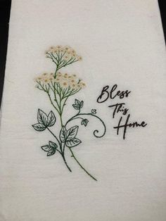 a white towel with embroidered flowers and the words, blossom to the home on it