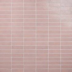 a white toilet sitting next to a pink tiled wall