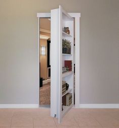 an open door in the middle of a room with shelves on each side and bookshelves below