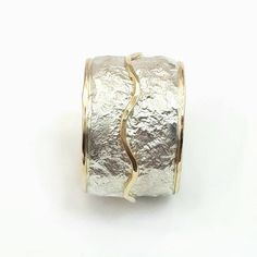 This is a wide, bold ring, chunky but not heavy, that makes a statement. It has a crumpled tinfoil texture with a wavy gold stripe soldered on top. Width: 0.56 inch / 14 mm Thickness: 0.1 inch / 2.5 mm This listing is for sizes 4-13- Just convo me your size. For other sizes - please convo me. Additional information If you liked this item, you may also want to look at these pieces: http://etsy.me/2fWkafJ http://etsy.me/2eI2vT3 For customer reviews of our shop: http://etsy.me/2eOQZZt Back to our s Unique Hammered Wide Band Rings, Elegant Wide Band Hand Cast Jewelry, Elegant Hand Cast Wide Band Jewelry, Unique Silver Jewelry With Unique Texture, Silver Jewelry With Unique Texture, Wide Band Silver Hammered Jewelry, Unique Wide Band Hammered Jewelry, Hammered Wide Band Ring As Gift, White Gold Jewelry With Hammered Wide Band