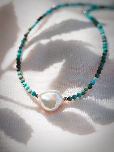 "This dainty turquoise choker necklace comes accented with a single Keishi pearl that puts forth a glistening glow. Layer these with our other beaded beauties for an elegant boho statement. ✦ DETAILS ✦ ✧ Name: Kawena (ka-VEH-na) - the glowing one. ✧ Adjustable Length from: 14.5\"-17\". ✧ Genuine 2.5mm faceted Turquoise Beads. ✧ Genuine 10mm avg. AAA Keishi Pearl. ✧ 14kt Gold Filled Components, Extender, and Clasp. ✧ All Ke Aloha Jewelry pieces come packaged thoughtfully, beautifully, and ready f Bohemian Turquoise Jewelry With Pearl Charm, Bohemian Single Strand Pearl Jewelry, Turquoise Beaded Necklace With Pearl Charm As Gift, Elegant Hand-strung Turquoise Beaded Necklaces, Elegant Turquoise Beaded Necklace Hand-strung, Turquoise Bohemian Beaded Necklaces With Pearl Charm, Turquoise Round Beads Pearl Necklace With Natural Stones, Turquoise Pearl Necklaces With Pearl Charm, Turquoise Pearl Beaded Necklaces As Gift