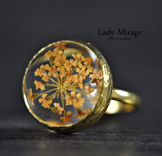 The ring was made with real flowers which was cast in glass-like resin.  The cheerful peach color reminds you of sunny autumn days. In keeping with the warm tone, the ring is adorned with a gold-plated setting. It can be combined with any outfits, whether chic, classic or in everyday life. What is certain is that you will attract attention! You can find the matching earrings and bangle in our shop under the following link: https://www.etsy.com/de/listing/834017216/echte-bluten-ohrringe-peach-vergoldet?ref=shop_home_active_3&frs=1 https://www.etsy.com/de/listing/847921319/echte-bluten-armreif-peach-vergoldet?ref=shop_home_active_1&frs=1 Size: adjustable and fits every finger ! Flower's Cabochon : 1,6 cm ♥ Handmade with Love Lady Mirage is a designer jewelry label from Berlin. We manufacture Gold Flower-shaped Nature-inspired Rings, Gold Rings With Pressed Flowers For Wedding, Nature-inspired Gold Flower Ring, Gold Flower Ring Nature-inspired, Gold Nature-inspired Flower Ring, Vintage Resin Rings For Gifts, Handmade Gold Flower Ring Nature-inspired, Handmade Gold Flower Ring, Nature-inspired, Peach Flower-shaped Jewelry For Gift