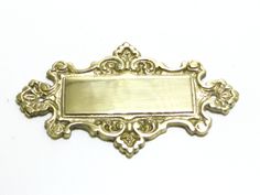 a gold plate with an ornate design on the front and back side, sitting on a white surface