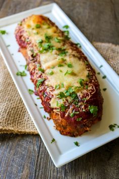 meatloaf covered in sauce and parmesan cheese on a white platter