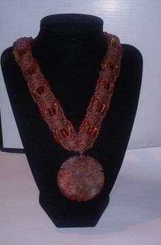 As the autumn equinox nears, the leaves begin to turn, the nights longer, the days shorter. The air becomes crisper. There is a smell of apple and wood smoke in the air. The world is alive in color. The splendor in orange, yellow, red, and brown. Keep the colors and the spirit of autumn with Autumn Delight.  This necklace features an orange and cream stone pendant with a carved leaf. It hangs from a thick brown macrame necklace with orange, yellow, and red beads. If you need the necklace larger Unique Brown Macrame Necklace, Hippie Brown Macrame Necklace, Nature-inspired Brown Macrame Necklaces, Hemp Macrame, Brown Macrame, Cream Stone, Holiday Necklace, Hemp Necklace, Halloween Bracelet