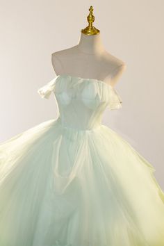 Step into a dreamlike world of elegance and charm with this Sage Green Fairy Ball Gown. The ball gown silhouette gracefully cascades into a floor-length skirt, creating a captivating and ethereal look. The strapless neckline highlights your shoulders and neckline, adding a touch of timeless elegance. It is crafted from soft tulle fabric and is adorned with intricate 3D floral appliques, bringing depth and a fairytale-inspired allure to the design. The zipper back ensures a sleek and seamless fit Spring Green Ball Gown, Green Tulle Dress For Debutante Ball, Green Organza Ball Gown, Green Organza Ball Gown Evening Dress, Spring Wedding Green Ball Gown, Green Tulle Ball Gown For Banquets, Green Tulle Ball Gown For Banquet, Green Organza Evening Dress For Prom, Organza Floor-length Ball Gown