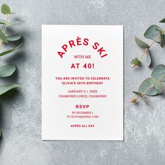 a red and white card with the words apres ski on it next to eucalyptus leaves