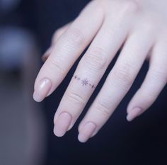 a woman's hand with a small star tattoo on her left thumb and finger