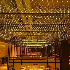 a restaurant with tables and chairs covered in lights