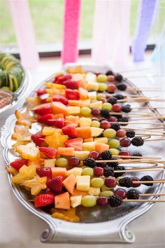 fruit skewers are lined up on a platter