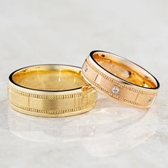 two gold wedding bands with diamonds on them