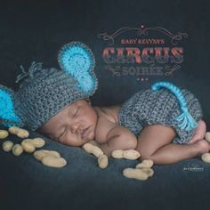 a newborn baby wearing a crocheted mouse hat and sleeping on his side with peanuts