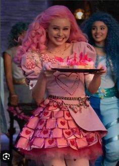 a woman in a pink dress holding a plate with cupcakes and hearts on it