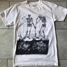 Organic Cotton Never Worn Surfing Skeletons T-Shirt Small By La Based Clean Aesthetics . Made In The Usa. Off White Color. Never Worn, Tags Removed. Summer Band Merch T-shirt With Back Print, Grunge Graphic Print Summer Tops, Vsco Style Crew Neck T-shirt For Streetwear, White Vsco T-shirt With Text Print, Fitted Cotton T-shirt For Beach, White Crew Neck T-shirt For Surfing, Spring Vsco Streetwear Tops, Unisex Summer T-shirt With Crew Neck, Unisex Summer Crew Neck T-shirt