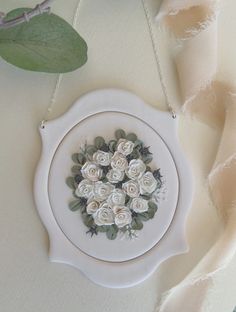 there is a white flower arrangement in the center of this frame on a tablecloth