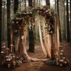 an outdoor wedding setup with candles and flowers on the ground, surrounded by tall trees