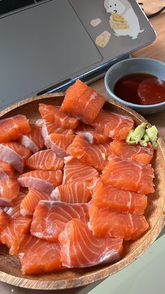 a wooden plate topped with lots of fish next to a bowl of ketchup