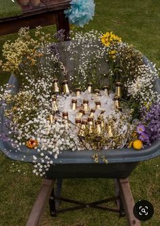 a wheelbarrow filled with lots of bottles and flowers