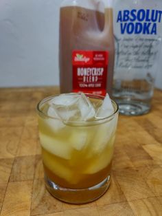 an alcoholic drink with ice in it on a wooden table