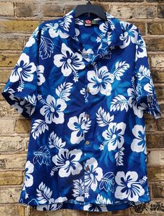 a blue hawaiian shirt hanging on a brick wall