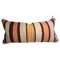 an orange and brown striped pillow on a white background