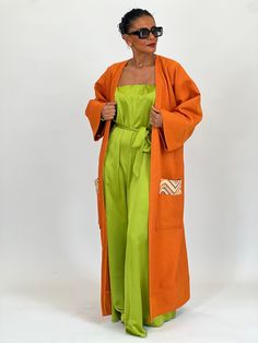 The Joranïa long kimono in bright shades of orange, embellished with a distinctive touch at the back and colorful badges on the pockets, creates a bold and personalized look, embodying individuality and creative style. Model is wearing a standard size - Model's measurement: 1m65 for a size 36 - Kimono length: 125cm *The kimonos are suitable for a 36 up to 44 *Delicate wash. Casual Orange Kimono For Spring, Casual Orange Spring Kimono, Summer Cotton Outerwear With Side Pockets, Spring Workwear Kimono With Kimono Sleeves, Spring Workwear Kimono, Bohemian Orange Outerwear For Summer, Long Orange Outerwear For Spring, Summer Bohemian Orange Outerwear, Long Orange Spring Outerwear