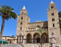 an old building with two towers and palm trees