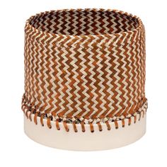 a brown and white basket with tassels on the bottom, sitting in front of a white background