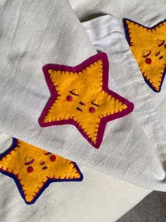 two yellow and red stars are on white fabric, one is embroidered onto the other