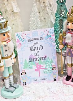 two nutcrackers are next to a sign that says welcome to the land of sweets