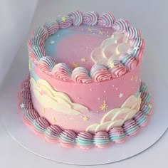 there is a pink and blue cake with clouds on it