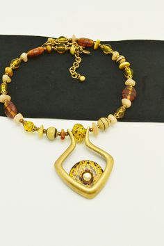 This great necklace from Chico's is strung on memory wire, and is adjustable, so it will fit a variety of sizes. Glass beads in shades of amber, cream and browns are accented by a pendant with a glass donut. This necklace will go with a lot of different outfits, and is sure to become a favorite piece. Necklace is about 18 inches long, and has an adjustment of about 4 inches. For more lovely vintage accessories, please visit: www.etsy.com/shop/CloesCloset?section_id=10559789 Handmade Retro Brown Necklaces, Retro Handmade Brown Necklaces, Retro Brown Handmade Necklaces, Unique Adjustable Amber Beaded Necklace, Adjustable Retro Gold Necklace, Retro Adjustable Gold Necklace, Adjustable Brown Vintage Necklace, Vintage Brown Adjustable Necklace, Retro Adjustable Brown Jewelry