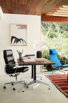 an office with a desk, chair and rug in the middle of it is shown