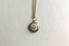 This sweet, small, antique brass locket has a vintage glass Pink rose cabochon set on the front, giving it the perfect cottage core feel.  It hangs on a 16" gold stainless steel chain necklace.  The locket is approximately 14mm.  The glass cabochon is 8mm.  Arrives in an eco-friendly jewelry box, ready for gifting. MORE lockets in my shop! FREE SHIPPING! THANK YOU FOR VISITING MY SHOP! Vintage Adjustable Locket Necklace, Vintage Brass Locket Necklace Nickel Free, Vintage Brass Locket Necklace Nickel-free, Vintage Nickel-free Brass Locket Necklace, Vintage Brass Nickel-free Locket Necklace, Classic Brass Locket Necklace With Vintage Charm, Vintage Adjustable Jewelry With Pressed Flowers, Vintage Brass Locket Necklace, Vintage Brass Round Locket Necklace